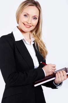 Portrait of pretty smiling businesswoman holding notepad and pen