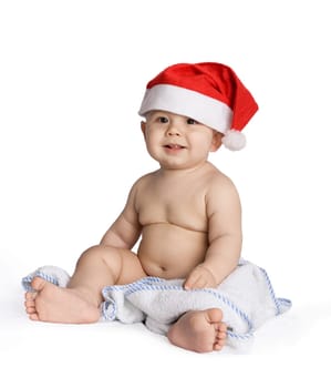 Image of isolated sweet baby in santa cap sitting on blue nappy