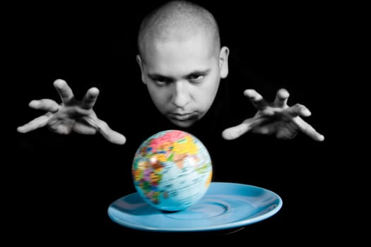 Conceptual image of earth model on saucer with magician keeping his hands over it