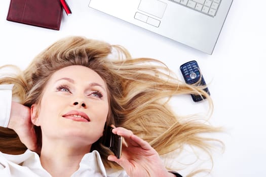 Close-up of a young businesswoman lying and chattering on the phone
