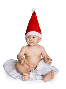 Portrait of cute baby wearing santa cap and sitting on blue napkin