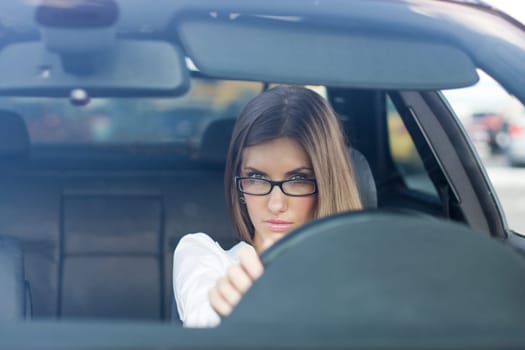 Image of young female driving her new car and looking at road