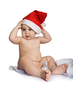 Photo of adorable toddler touching santa cap on his head and looking aside