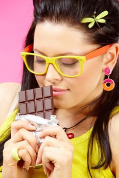 Young woman enjoys and holds chocolate in bar