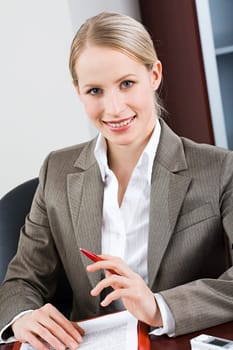 Portrait of bossy woman sitting at a table and looking at camera