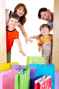 Image of cheerful family members near colorful shopping bags looking with happy expression