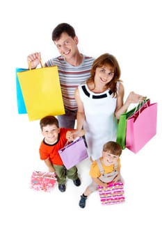 Photo of friendly parents and siblings with bags smiling at camera