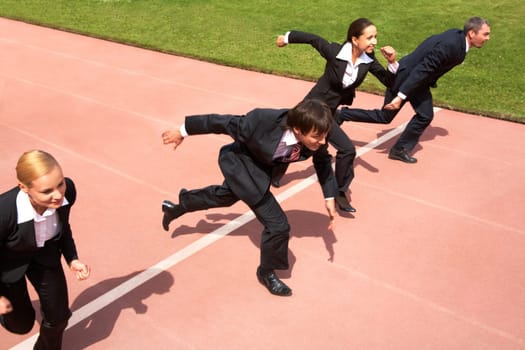 Photo of business people running on sport track