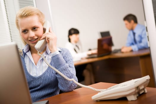 Busy secretary speaking on the phone in the office