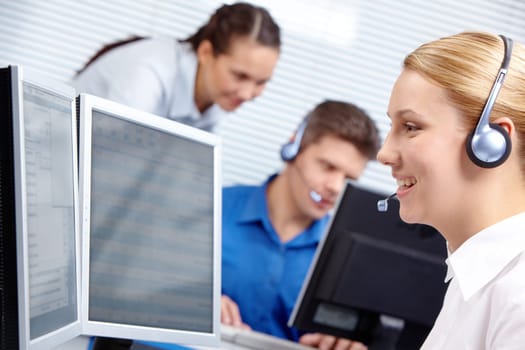 Portrait of customer representative working on the background of colleagues