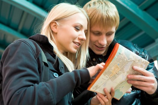 Photo of pretty girl and handsome guy looking at city map outside
