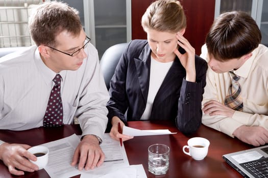 Portrait of professionals sitting at the table and looking at a document