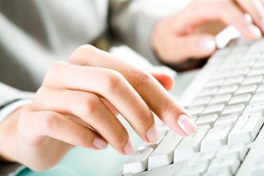 Close-up of female hand over keypad typing business documents