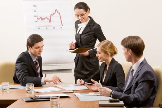 Image of business team looking at document and discussing it in office
