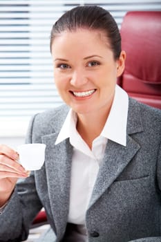Portrait of happy professional with cup of coffee in hand looking at camera with smile