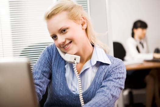 Busy secretary speaking on the phone in the office