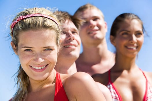 Face of charming girl looking at camera with group of friends behind