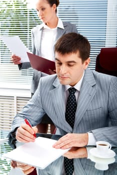 Portrait of serious boss going to sign contract while executive secretary standing near by