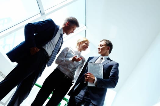 Three smart employees discussing new strategy at meeting