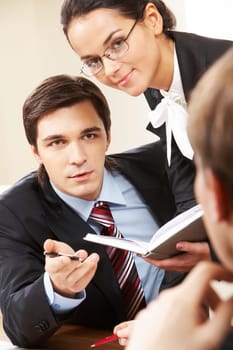 Photo of serious businessman looking at his partner with pretty female near by