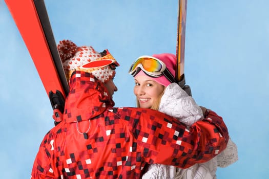Portrait of happy female looking at camera while being embraced by sporty man