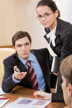 Photo of serious businesswoman looking at camera with smart partner near by