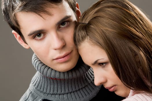 Handsome guy looking at camera with lovely girlfriend by his side
