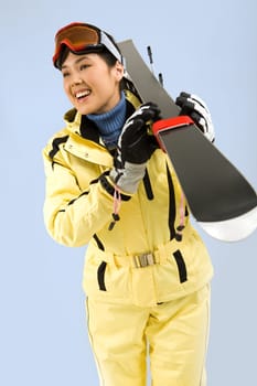 Portrait of pretty woman in sportswear carrying her skis