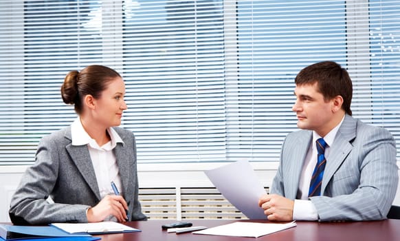 Photo of confident business partners looking at each other during formal communication