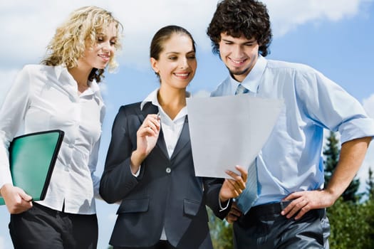 Businesspeople are discussing together a new contract on the street