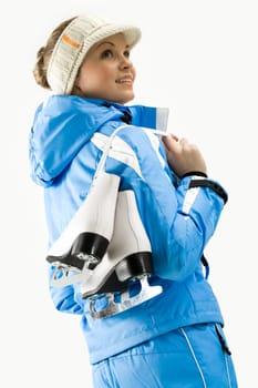 Portrait of young woman holding skates on a white background