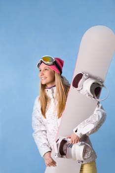 Portrait of healthy woman with pair of skis in hands looking aside and smiling