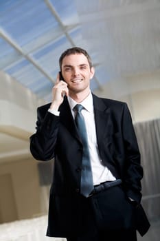 Photo of handsome employer speaking on the phone with potential business partner