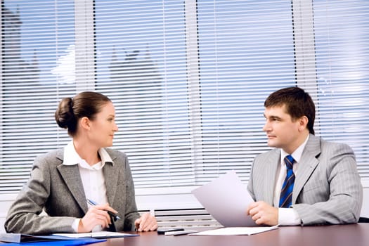 Photo of confident business partners looking at each other during formal communication
