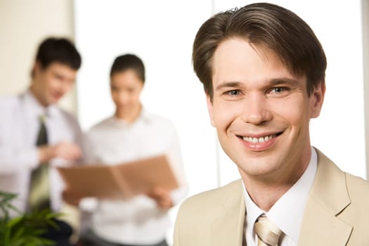 Portrait of people working with smiling businessman in front