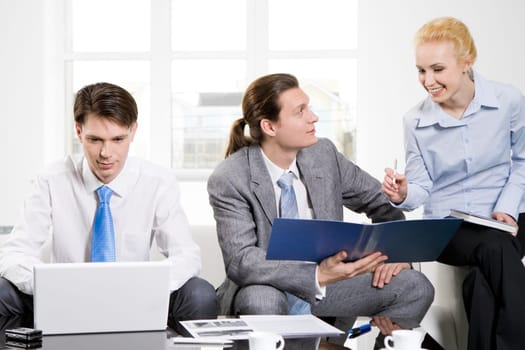Image of executive employees consulting about new project while businessman typing on laptop