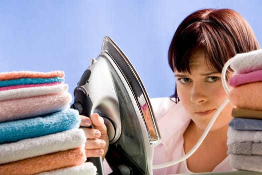 Portrait of young female between two stacks of colorful towels looking to camera