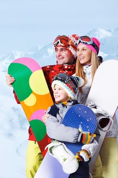 Portrait of happy family with snowboards on winter resort