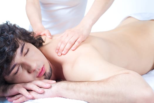 Portrait of young man with closed eyes and getting a relax massage
