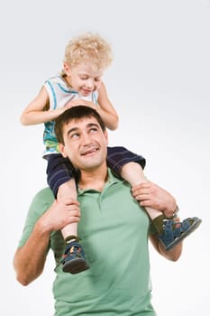 Photo of little boy sitting on fathers neck looking at his eyes