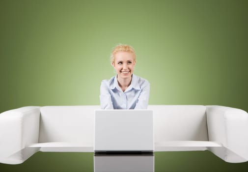Image of white collar worker sitting before laptop in office over green background