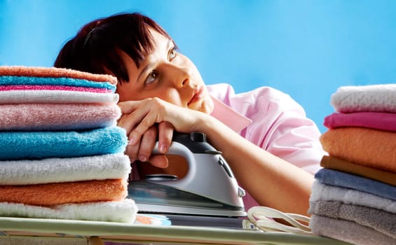 Portrait of young female between two stacks of colorful towels looking upwards