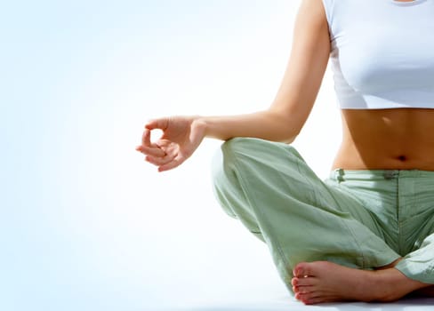 Close-up of females torso during meditation with legs crossed and hand being kept on her right knee