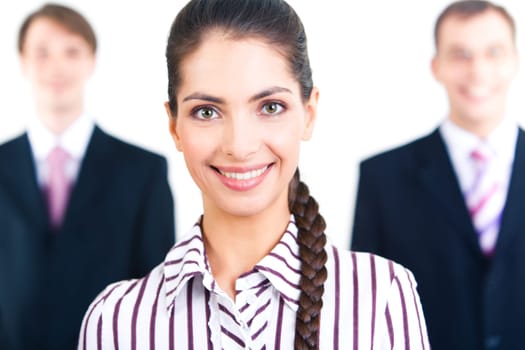 Portrait of smiling woman looking at camera on the background of two businessmen