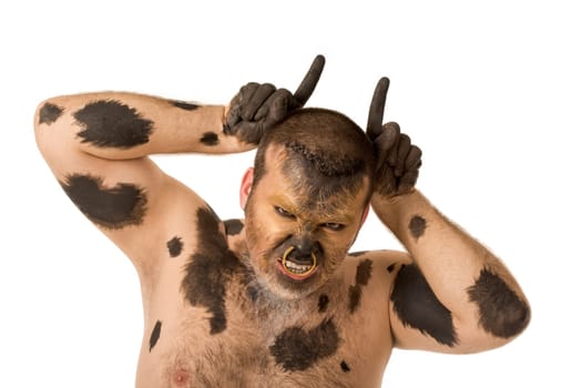 Portrait of painted man showing horns and looking at camera with aggressive grimace