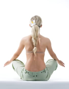 Rear view of meditating woman sitting over white background