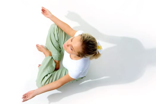 Above view of young woman meditating in pose of lotus
