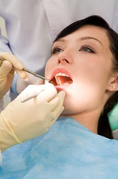 Close-up of inspection of oral cavity with help of hook and mirror