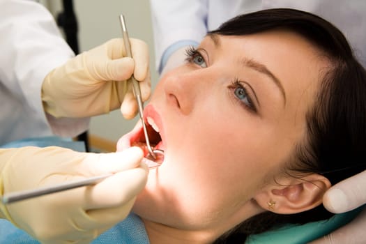 Close-up of female patient having her teeth examined by specialist