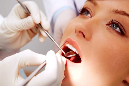 Close-up of female patient having her teeth examined by specialist